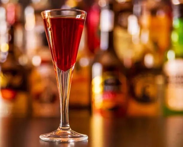 Photo of refreshing liqueur in a tall glass, alcoholic drink prepared by the bartender