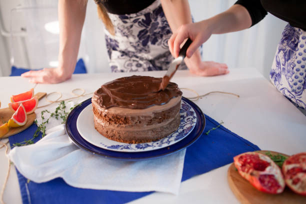 istock Home confectionery. Two girls making a cake on the kitchen. 1000712228