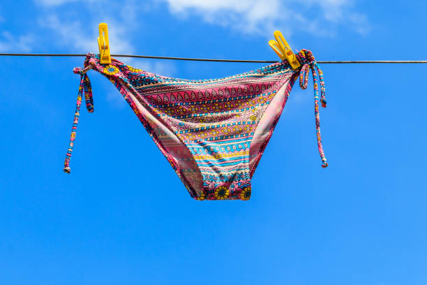 istock Drying female swimsuit hanging on a rope against blue sky 1000715578