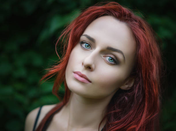 Portrait of attractive red haired young woman with blue eyes.