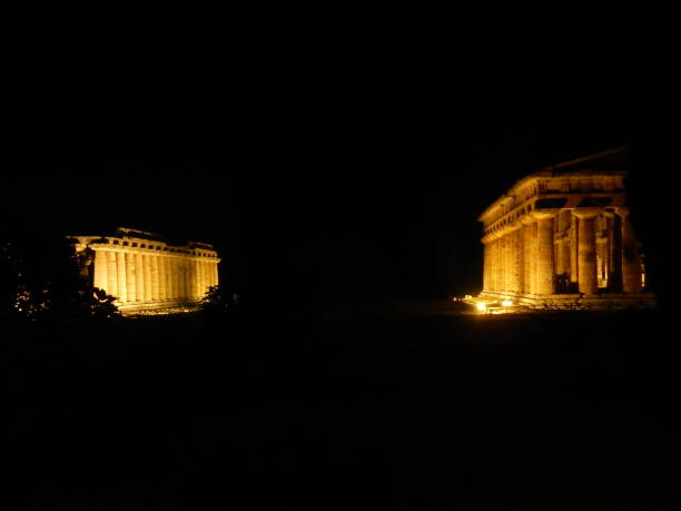 Paestum - Temples at Night Paestum, Salerno, Campania, Italy - June 30, 2018: Temples of Hera and Neptune in the Archaeological Park of Paestum temple of neptune doric campania italy stock pictures, royalty-free photos & images