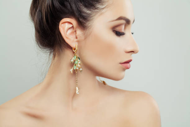 attraktive frau tragen goldene ohrringe mit weißen perlen und green gem - jewelry fashion model women gem stock-fotos und bilder