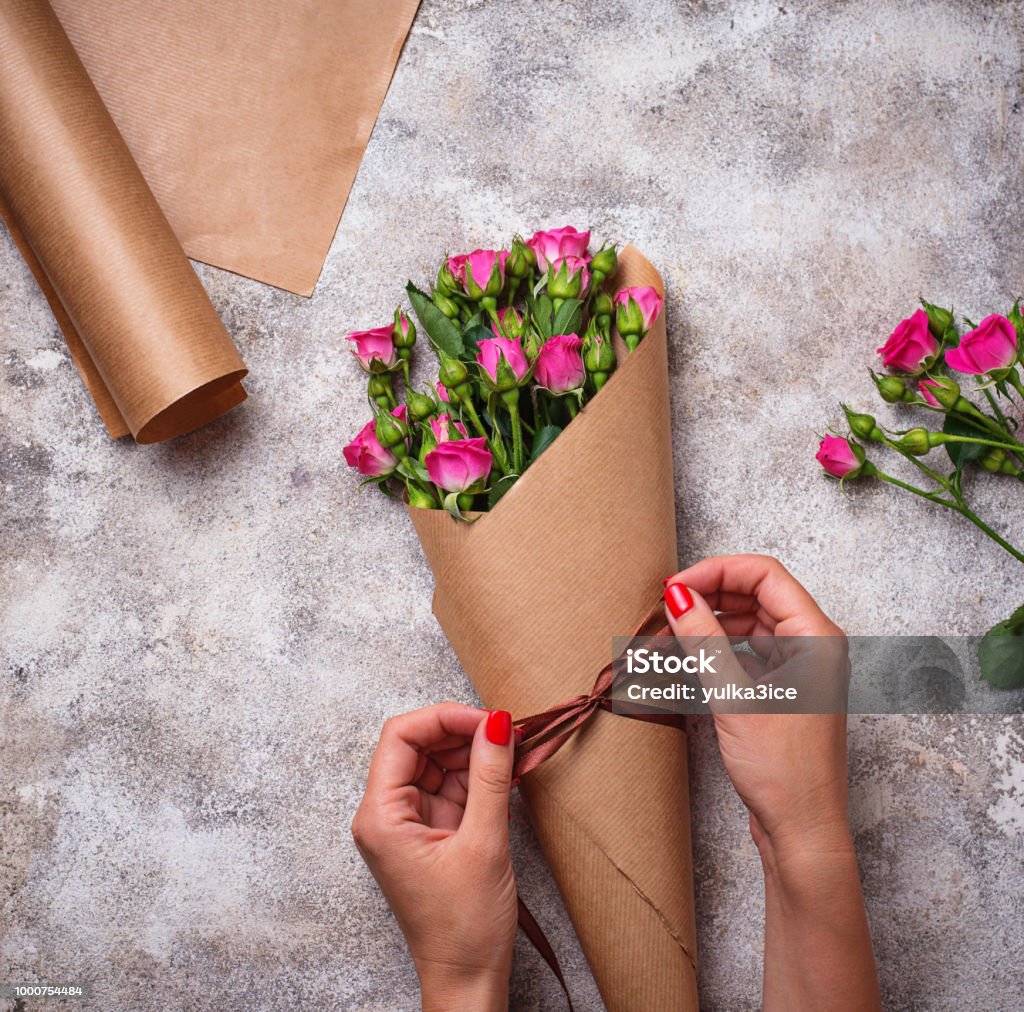 Womens Hands Wrap A Bouquet Of Roses In Paper Stock Photo - Download Image  Now - Adult, Backgrounds, Beauty - iStock