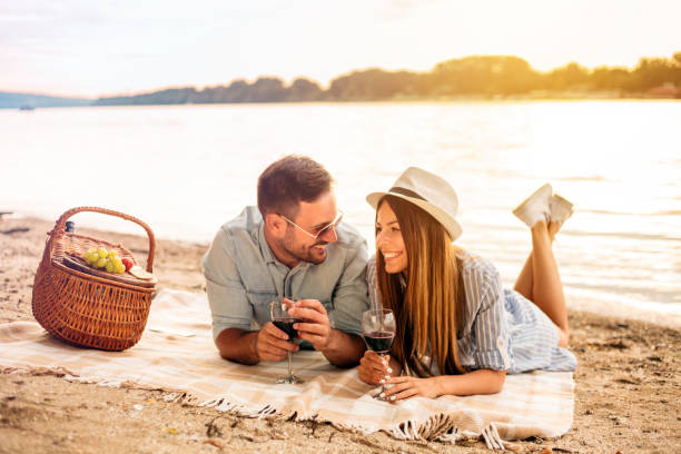 istock Happy young couple having a picnic at the beach 1000759188