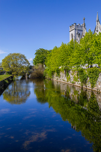 Corrib river with church, vegetation and reflection, Galway, Ireland