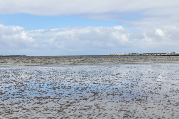 istock Ballyloughane Beach with houses in background and cloud reflection 1000785170