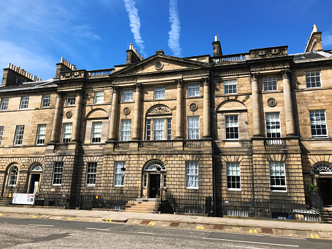 Edinburgh, Scotland - May 07 2018: Vapour trails in blue sky above elegant Georgian architecture of Bute House in Charlotte Square Edinburgh, official residence of the First Minister of Scotland