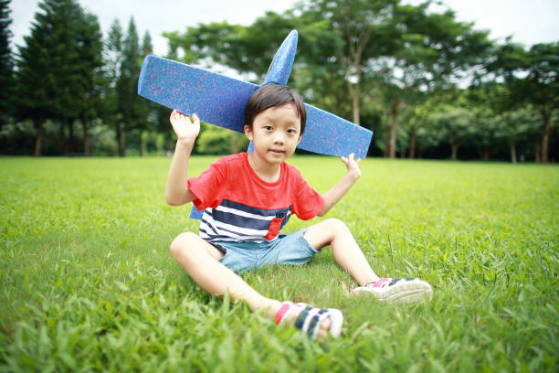 Boy hand holding a paper plane