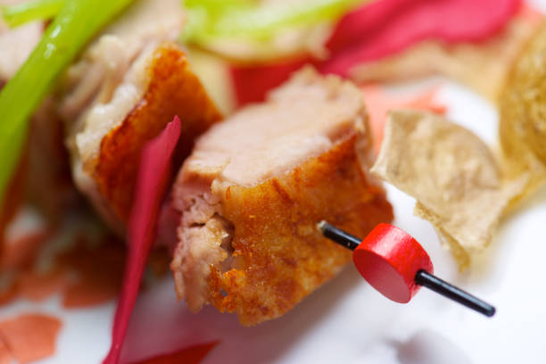 Closeup of a skewer of pork jowls.