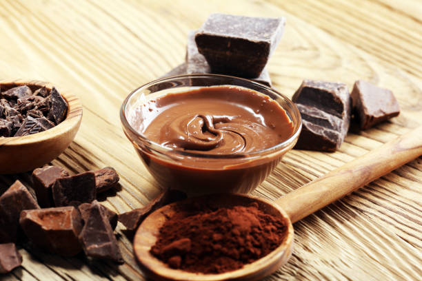 istock Melting chocolate  or melted chocolate with a chocolate swirl. Many stack and chips with powder. 1000804678