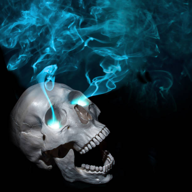 istock Halloween. Dead man and magic. Screaming human skull with eye smoke. Black background 1000831052