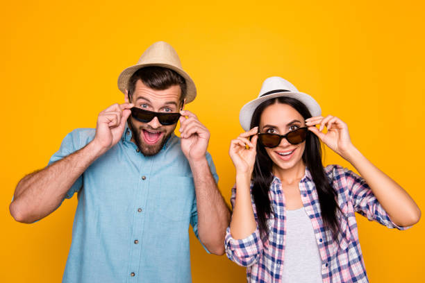 istock Portrait of surprised couple with unbelievable unexpected expression looking out black eyeglasses isolated on bright yellow background 1000833368