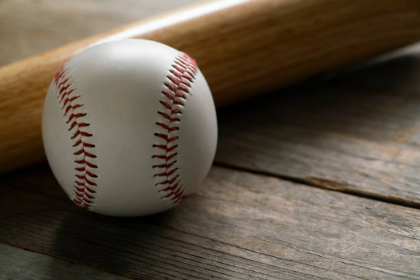 istock baseball and baseball bat on wooden table background, close up 1000834092