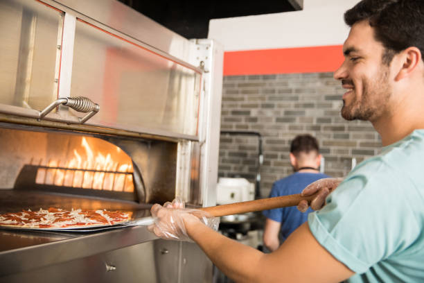 istock Chef baking pizza bread in oven at commercial kitchen 1000837874