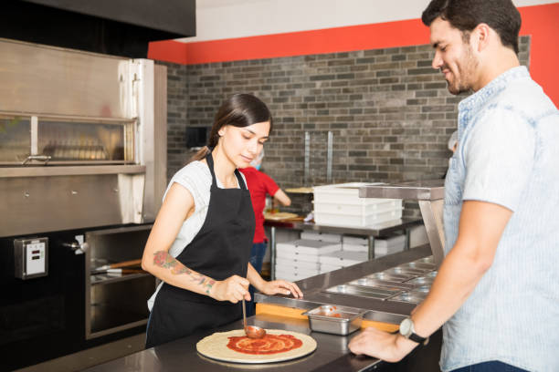 istock Chef smearing pizza dough with ketchup 1000838218