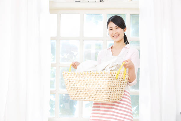 istock smiling Asian woman with the laundry 1000842394