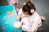 女の子が浴衣を着て日本の夏祭りをお楽しみください。