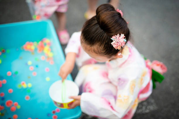 女の子が浴衣を着て日本の夏祭りをお楽しみください。 - 露店 ストックフォトと画像