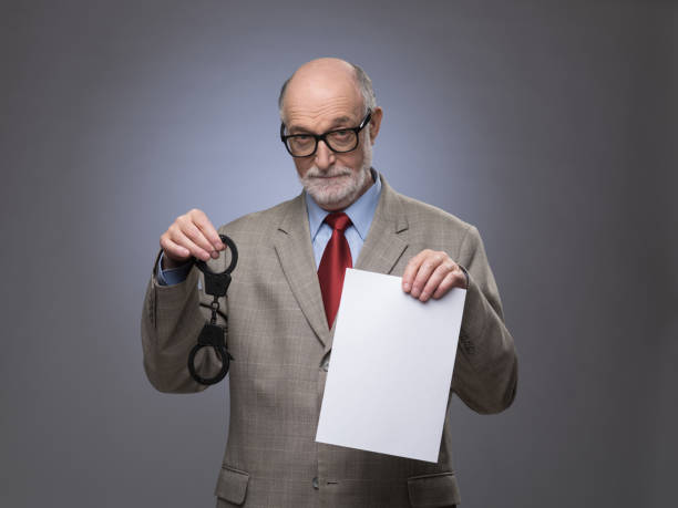 Senior man with handcuffs and paper