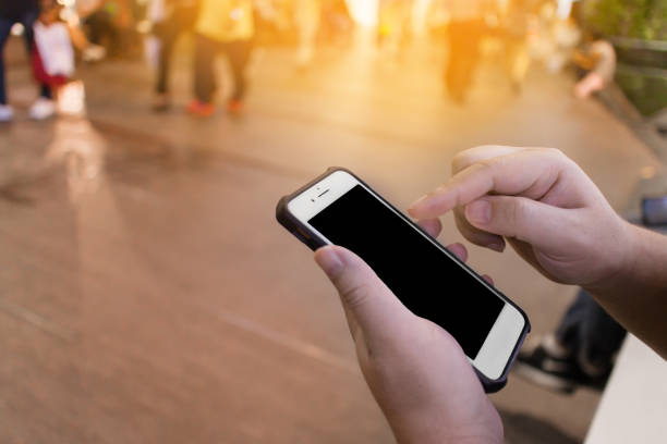 istock Selective focus on man's hand using smartphone and sitting at anight market, plaza, mall or department store 1000845426