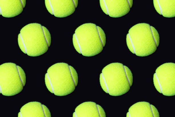 istock Pattern of tennis balls on black background 1000845668