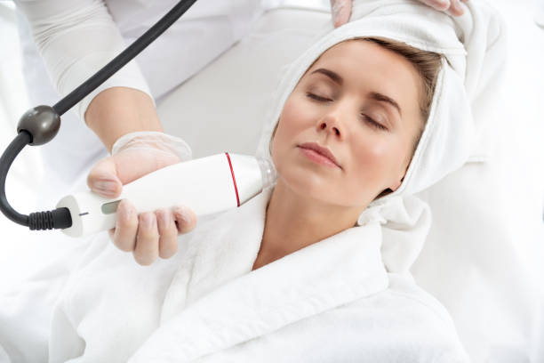 istock Glad girl getting cleaning face with appliance 1000845948