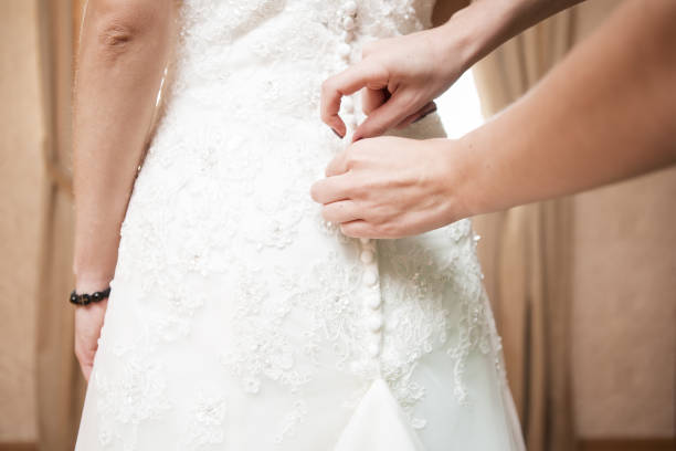 istock Helping the bride to put her wedding dress on. 1000849828