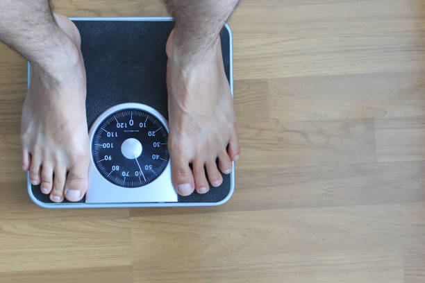 istock Male on the weight scale for check weight, Diet concept 1000854220