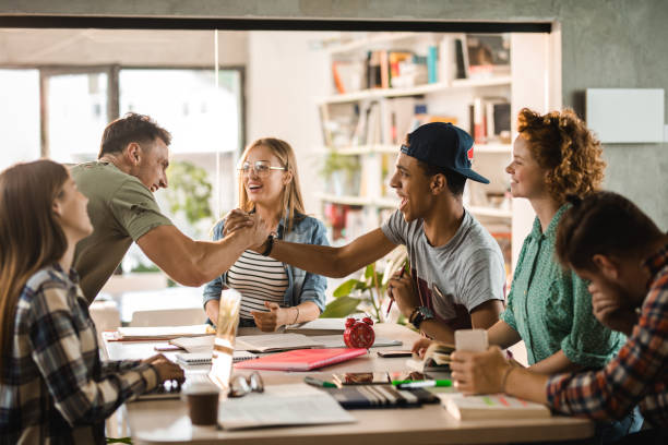 istock Cheerful male students giving each other manly greet in library. 1000857900