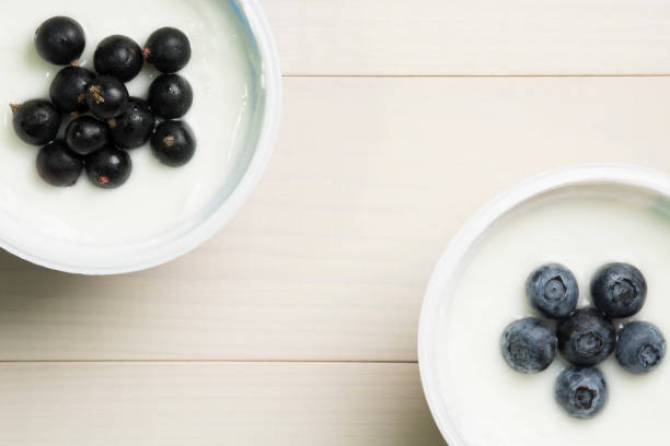 istock Yoghurt with berries. Blueberries and currants in yoghurt on a table. Top view, flat lay. Healthy breakfast 1000863370