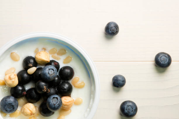 istock Yoghurt with berries. Blueberries, currants and nuts in yogurt on a table. Top view, flat lay. Healthy breakfast 1000863818
