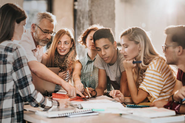istock Mature teacher teaching group of college students at campus. 1000868110