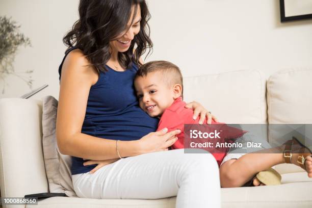 Boy Showing Love Towards Unborn Baby In Mothers Tummy Stock Photo - Download Image Now