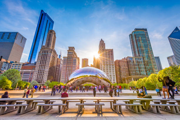 Cloud Gate in Chicago, Illinois CHICAGO - ILLINOIS: MAY 9, 2018: Tourists visit Cloud Gate in Millennium Park in the late afternoon. illinois photos stock pictures, royalty-free photos & images