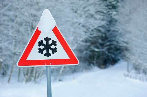 traffic sign warns of snow and ice at road