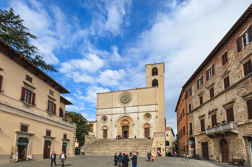 Tourists and locals in Piazza del Popolo, in the old town of Todi, a historic town in central Italy. In the square stands out the Cathedral, dedicated to the Annunciation of the Virgin Mary, dating to the thirteenth century and completed in the fourteenth century.