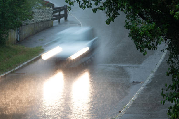istock silver Car driving the street down in the rain 1000902064