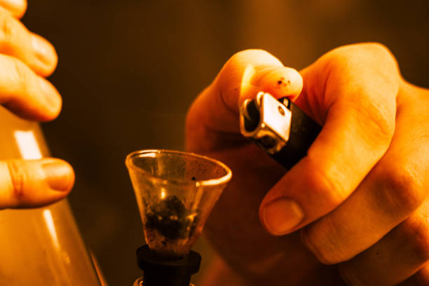 istock A man smokes cannabis weed, a joint and a lighter in his hands. Yellow toning 1000915352
