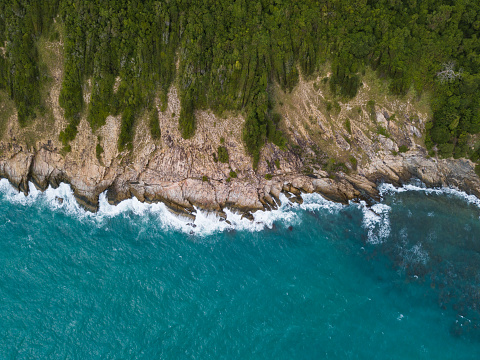 Sea waves breaking against  cliff viewed from above.