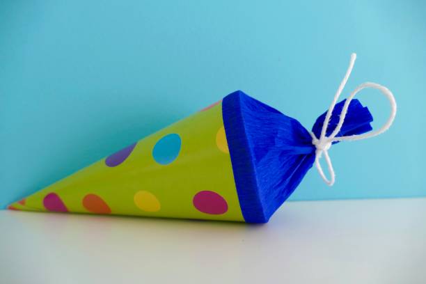 istock Multi colored conical bag of sweets on blue background 1000919160