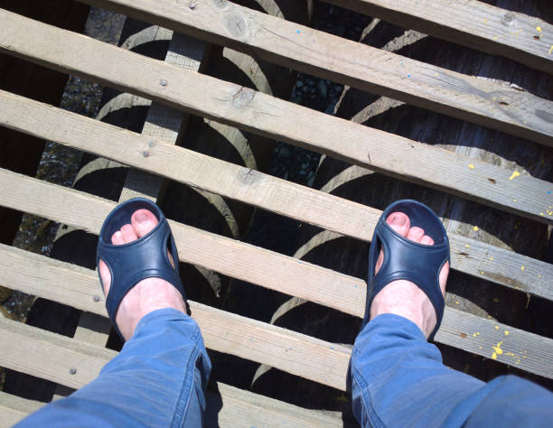 istock Feet on the bridge. Legs on a wooden bridge. 1000919284