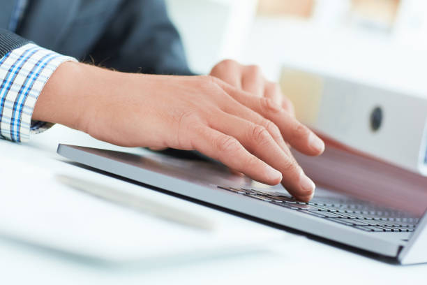 istock Businessman hands working on contemporary notebook, texting message keyboard 1000952168