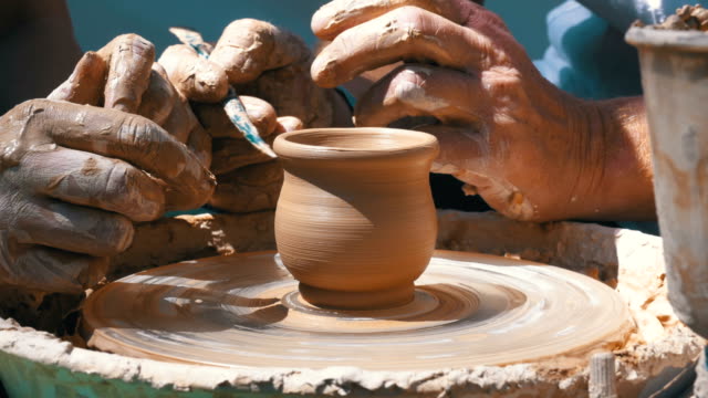 Hands of the Master Potter and Vase of Clay on the Potter's Wheel