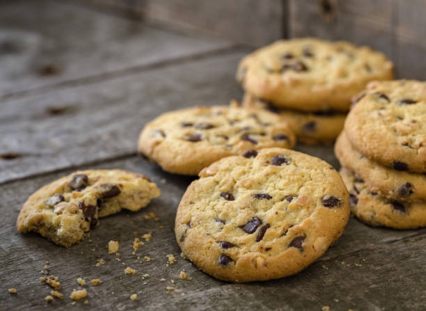 biscuits au chocolat arrondies sur naturel ancien bureau. - chocolate chip cookie cookie chocolate stack photos et images de collection