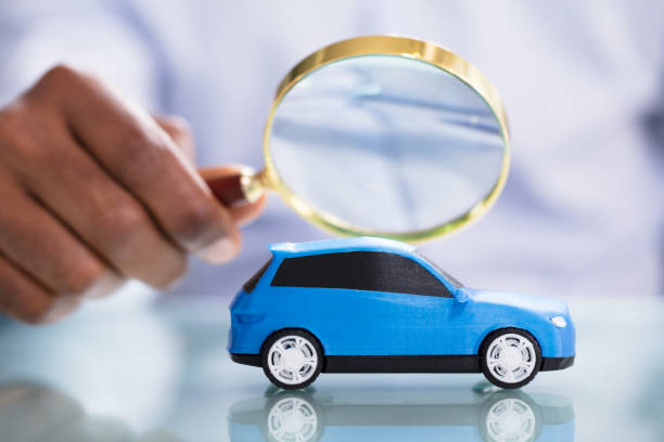 istock Person Looking Blue Car Through Magnifying Glass 1000962544
