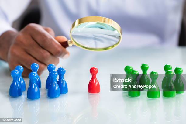 Male Looking At Colorful Pawns With Magnifying Glass Stock Photo - Download Image Now