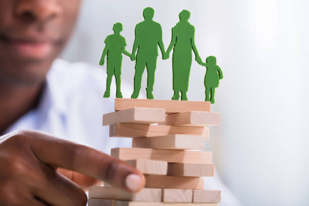 istock Person Holding Blocks With Green Family Figures 1000962564