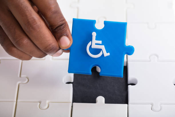 istock Hand Holding Disabled Wheelchair Icon On Jigsaw Puzzle 1000962660