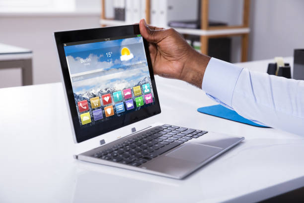 Close-up Of A Businessman Attaching Digital Tablet To Convertible Laptop