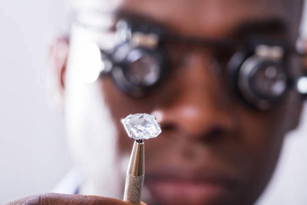 istock Person Looking At Diamond With Magnifying Loupe 1000963100
